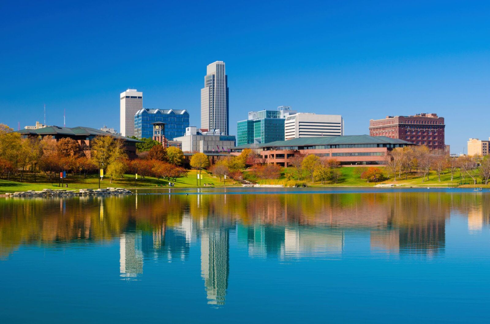 Omaha downtown skyline during Autumn, with a lake at the Heartland of America Park in the foreground