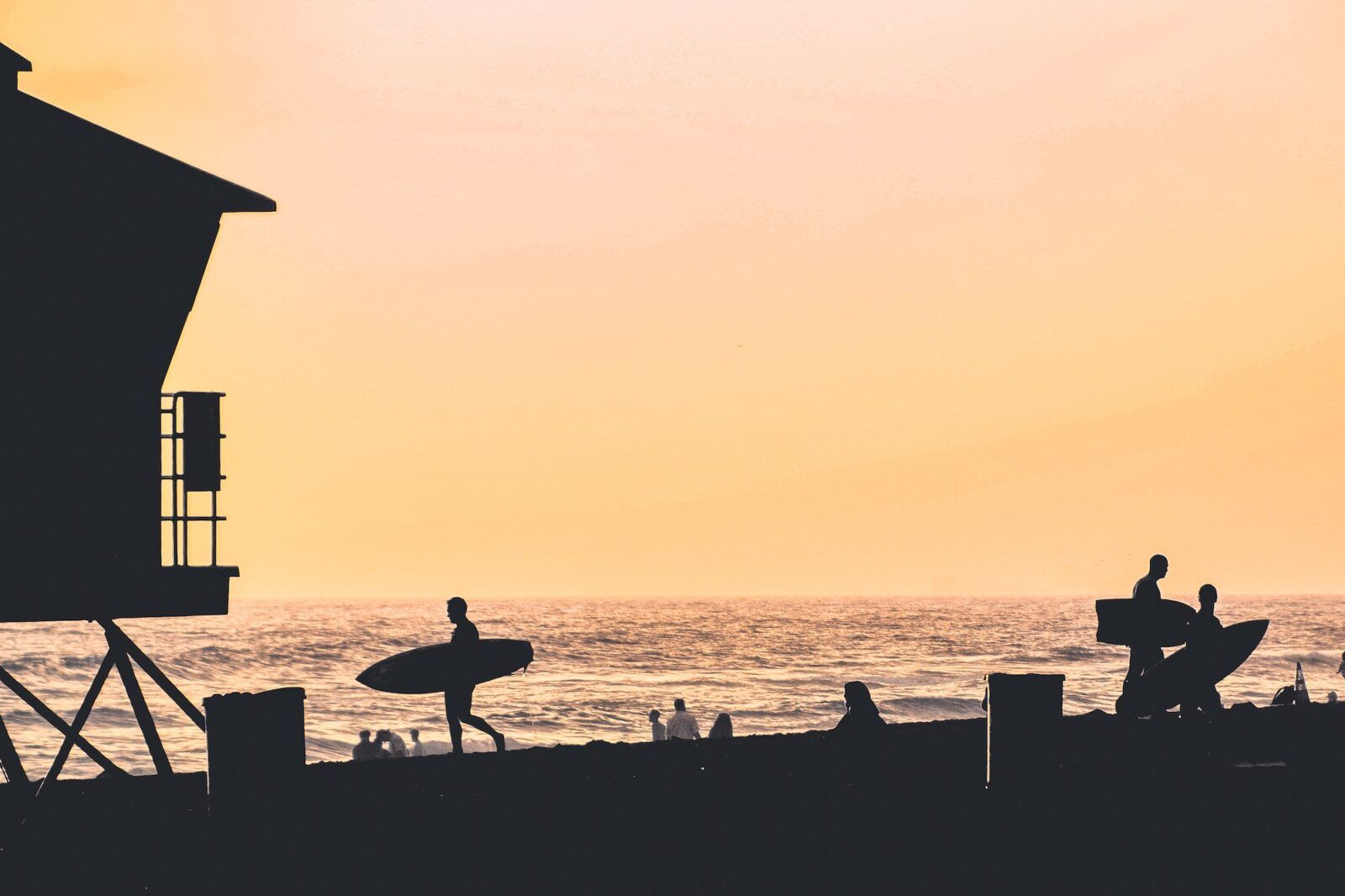 Silhouettes of surfers at the beach at sunset in Huntington Beach, California